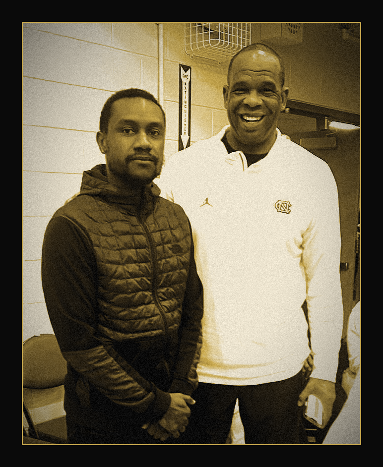 Photograph of Antonio Hicks, left, standing with another coach in a gymnasium.